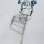 Empty shopping cart casting a shadow on white background.